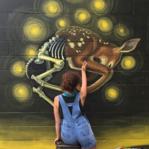Dayna Walton painting a mural