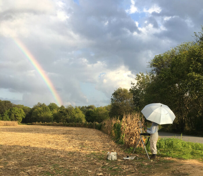 Susan Waters painting a rainbow in plein air